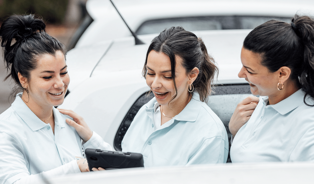 3 Pflegerinnen schauen auf ein iPad
